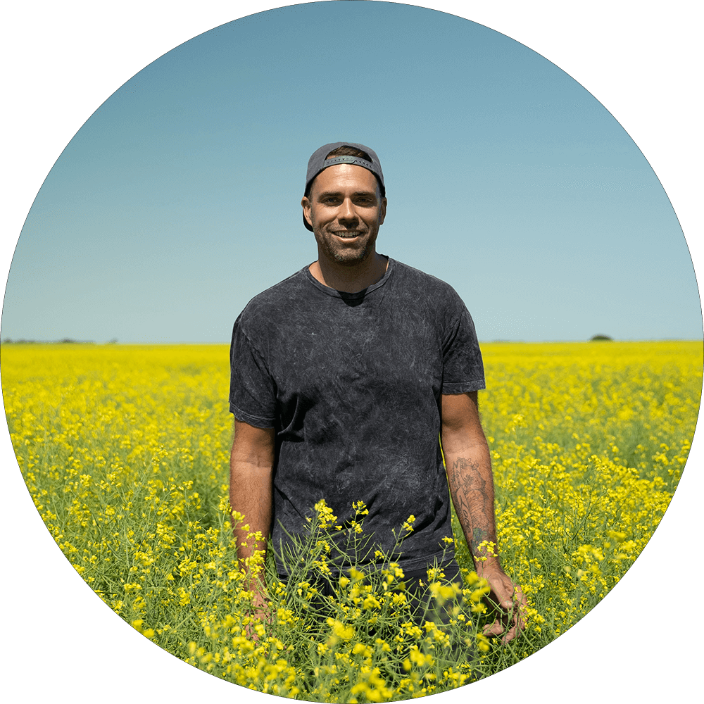 Will Bergmann standing in a field of canola
