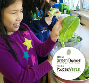 Two students holding plants in classroom 